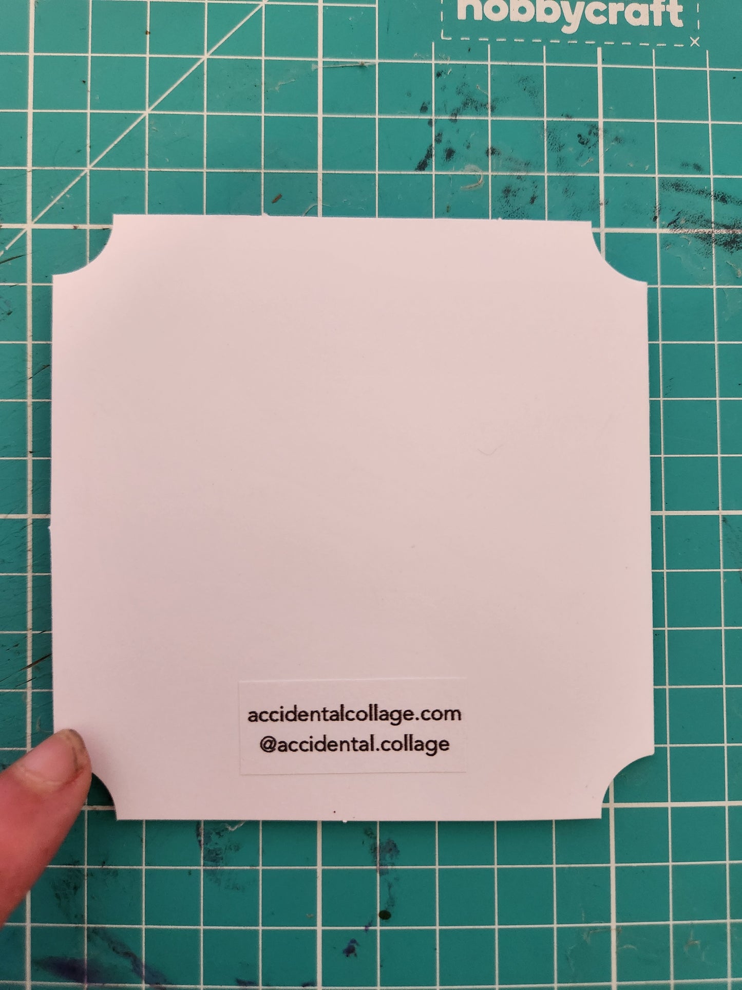 Back of a white square card with a small label at the bottom reading: accidentalcollage.com, @accidental.collage