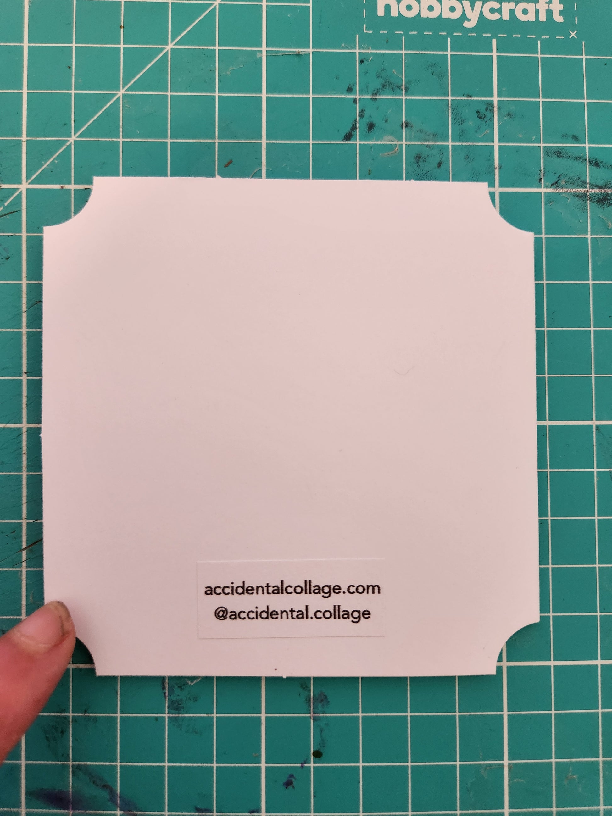 Back of a white square card with a small label at the bottom reading: accidentalcollage.com, @accidental.collage
