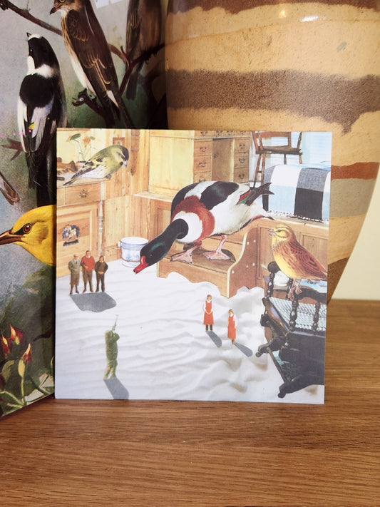 A square post card featuring a whimsical, collage of a duck hunting scene, displayed on a wooden surface in front of a striped ceramic vase.